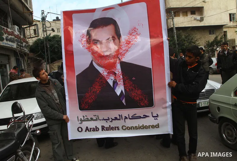 Palestinians hold a poster with a picture of Tunisia's former President Zine al-Abidine Ben Ali during a Hamas rally in Gaza City to show support for the Tunisian people on January 16, 2011. Tunisia's new leadership move...