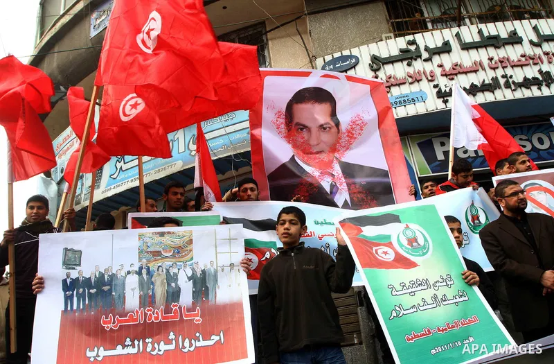 Palestinians hold posters during a Hamas rally in Gaza City to show support for the Tunisian people on January 16, 2011. Tunisia's new leadership moved to form a coalition government to gain the upper hand over violent l...