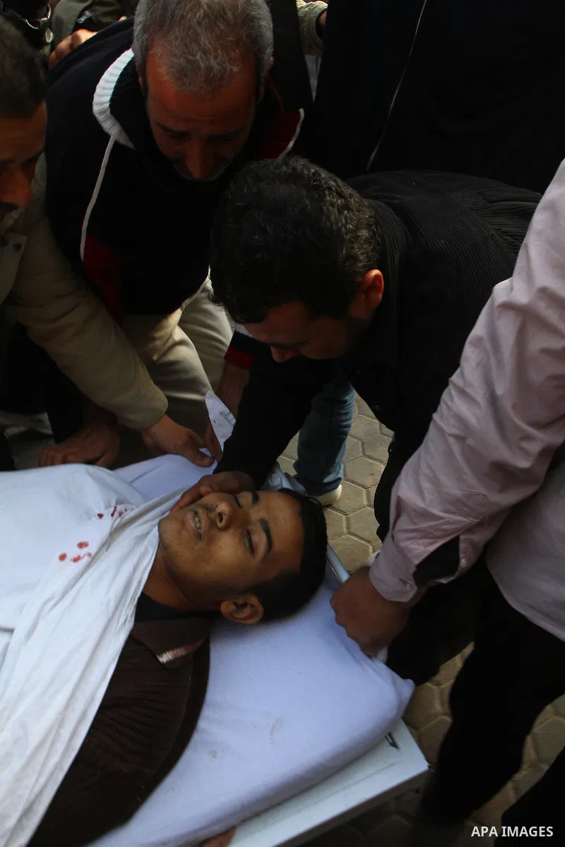 Palestinians look at the body of Amjad al-Zaaneen at a morgue in a hospital in the northern Gaza Strip town of Beit Hanon on Jan. 18,2011. An Israeli shell killed al-Zaaneen and injured two other, Palestinian hospital of...