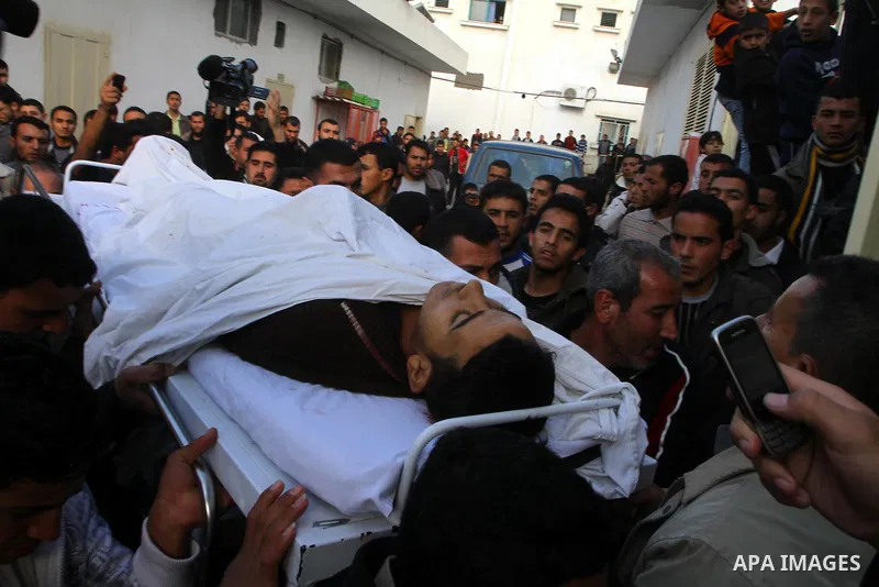 Palestinians carry the body of Amjad al-Zaaneen at a morgue in a hospital in the northern Gaza Strip town of Beit Hanon on Jan. 18,2011. An Israeli shell killed al-Zaaneen and injured two other, Palestinian hospital offi...