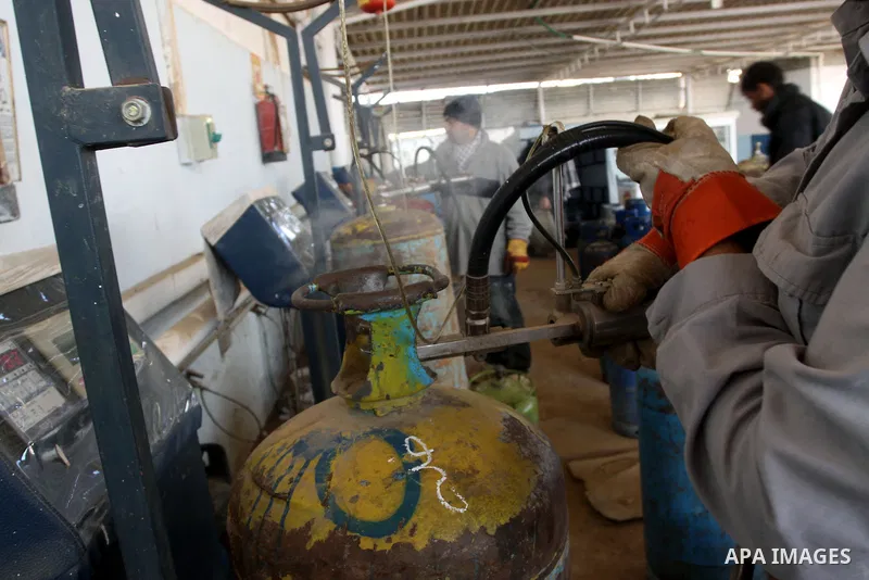 Palestinian workers fill an empty cylinders at a gas station in Gaza City, Jan. 19, 2011. Local officials said that the consumption of cooking gas mainly in houses, bakeries, hospitals, restaurants and farms during winte...