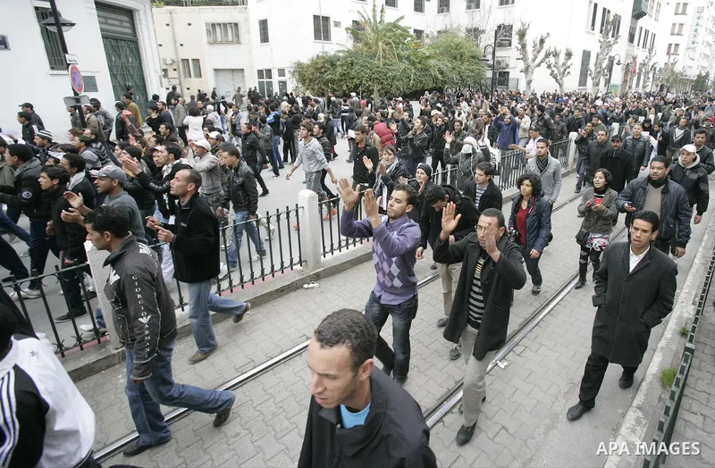 Tunisians take part in a demonstration against Tunisia's ruling Constitutional Democratic Rally party (RCD) in the center of Tunis, Jan. 18. 2011. Tunisian interim president Foued Mebazaa and Prime Minister Mohammed Ghan...