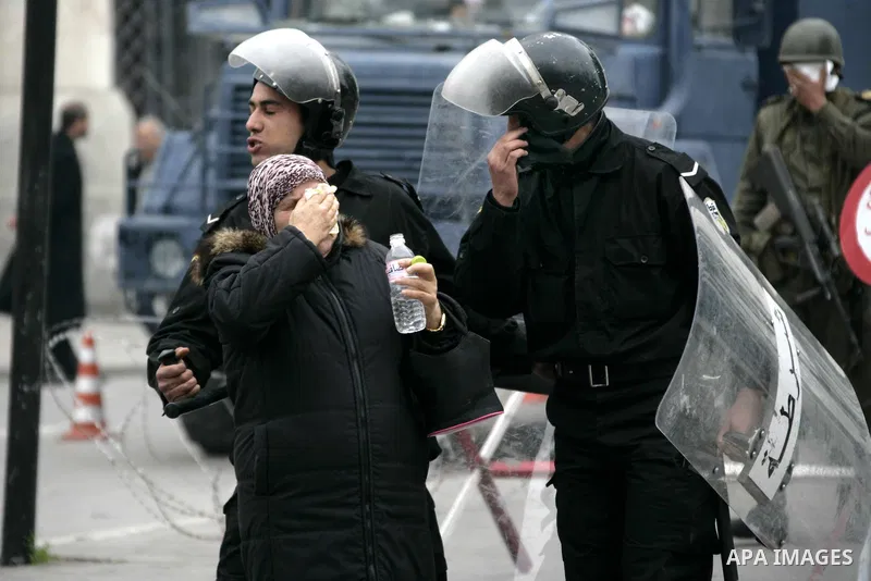 A Tunisian woman tries to protect herself from tear gas as protests still going on in Tunis 4 days after the Depature of the Tunisian President Zine El Abidine Ben Ali to Saudi Arabia, Tunisia, 18 January 2011. Tunisian...