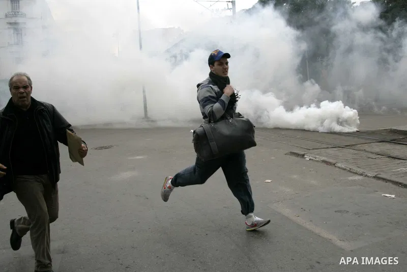 Protestors run away from tear gas as protests still going on in Tunis 4 days after the Depature of the Tunisian President Zine El Abidine Ben Ali to Saudi Arabia, Tunisia, 18 January 2011. Tunisian protesters called for...