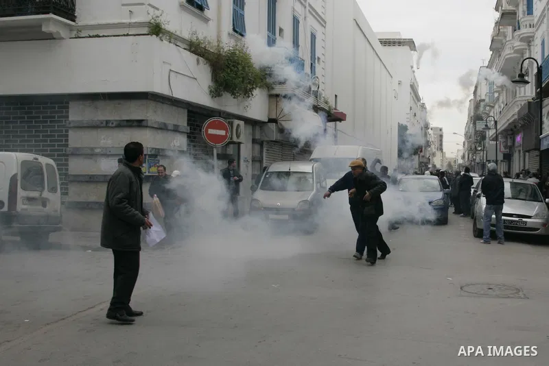 Tunisians run away as police use tear gas during a demonstration against Tunisia's ruling Constitutional Democratic Rally party (RCD) in the center of Tunis, Jan. 18. 2011. Tunisian interim president Foued Mebazaa and Pr...