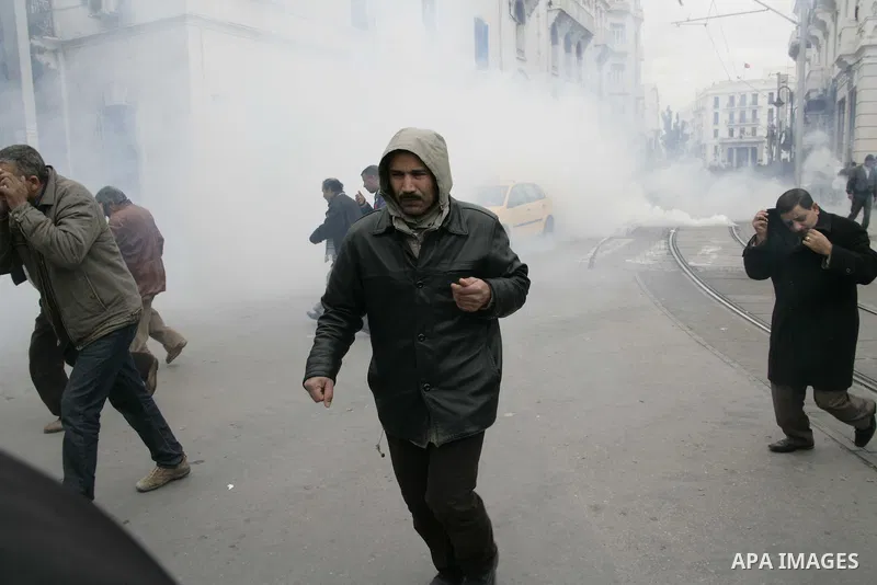 Tunisians run away as police use tear gas during a demonstration against Tunisia's ruling Constitutional Democratic Rally party (RCD) in the center of Tunis, Jan. 18. 2011. Tunisian interim president Foued Mebazaa and Pr...