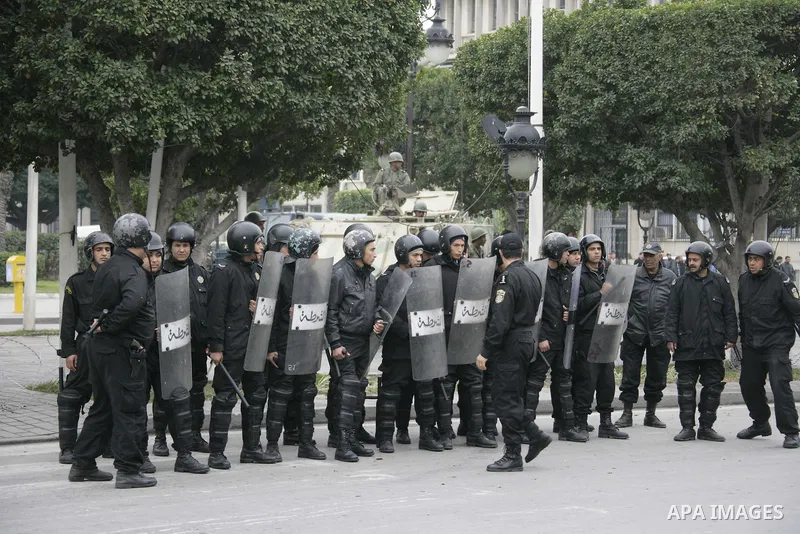 Tunisian policemen face protesters during a demonstration against the former ruling party Constitutional Democratic Rally (RCD) in central Tunis, Tunisia, 18 January 2011. Tunisia's reappointed Prime Minister Mohamed Gha...