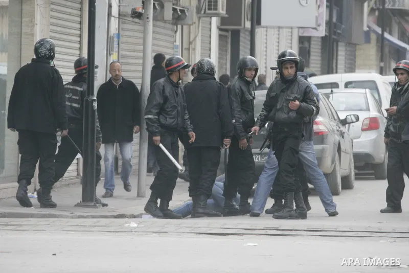 Tunisian policemen face protesters during a demonstration against the former ruling party Constitutional Democratic Rally (RCD) in central Tunis, Tunisia, 18 January 2011. Tunisia's reappointed Prime Minister Mohamed Gha...
