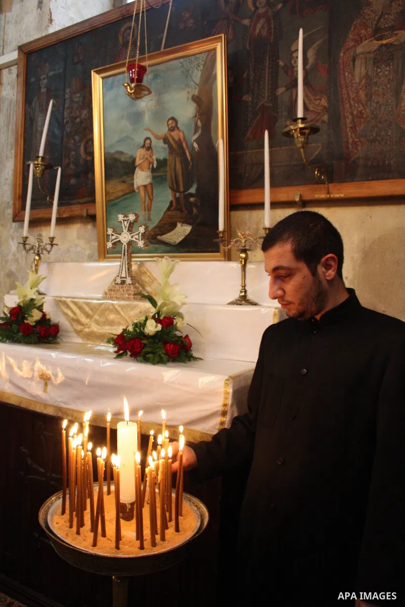 A worshipper lights a candle in the Church of the Nativity, the site revered as the birthplace of Jesus, in the West Bank town of Bethlehem, ahead of the Eastern Orthodox Christmas January 19, 2011. Photo by Najeh Hashla...