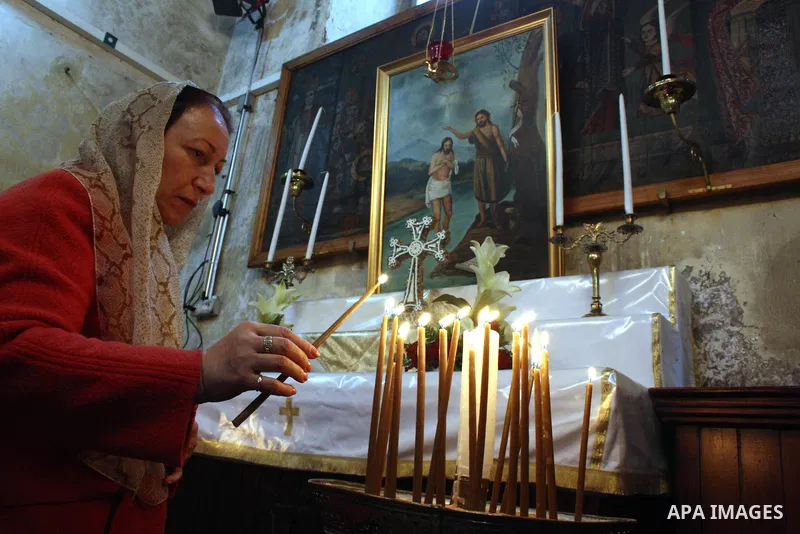 A worshipper lights a candle in the Church of the Nativity, the site revered as the birthplace of Jesus, in the West Bank town of Bethlehem, ahead of the Eastern Orthodox Christmas January 19, 2011. Photo by Najeh Hashla...