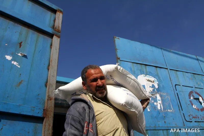 Palestinians receive aid flour sacks from a UN Relief and Works Agency (UNRWA) warehouse in Gaza city, on Jan. 19, 2011. Photo by Ashraf Amra