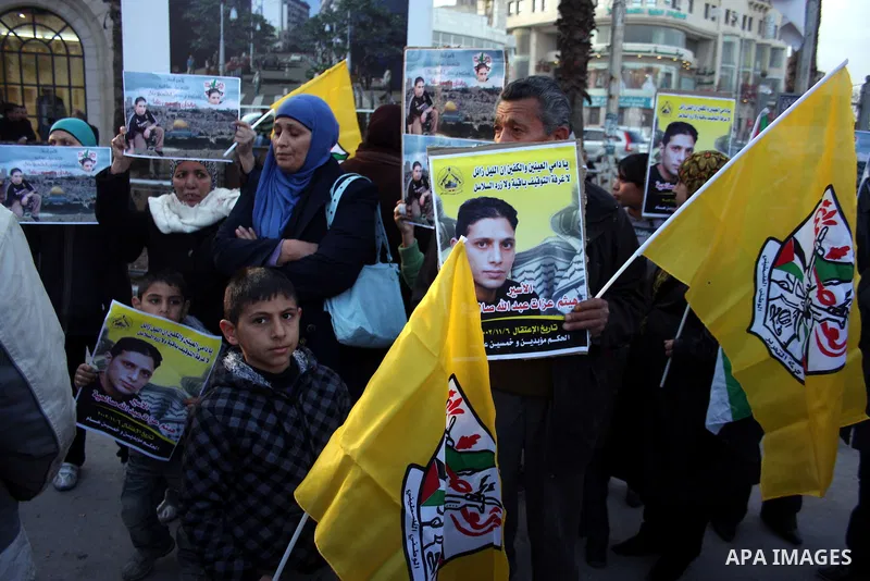 Palestinians carry a picture Haitham Ezzat Salheyah prisoner in the West Bank city of Ramallah January 19, 2011, the prisoner escaped an assassination attempt by the Israeli "Shabak" through customer tried to tuck a pill...