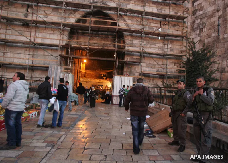 Palestinians walk near the restoration work in the old city wall of Jerusalem on Jan. 19,2011. Photo by Mahfouz Abu Turk