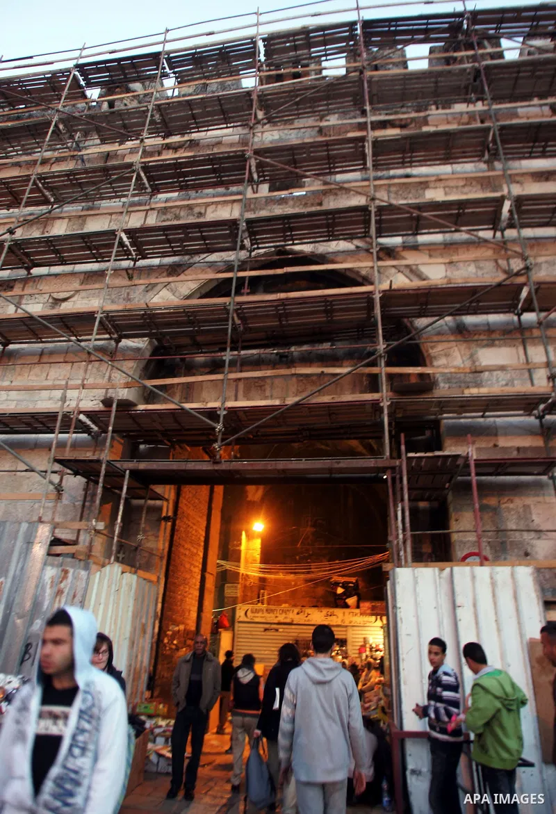Palestinians walk near the restoration work in the old city wall of Jerusalem on Jan. 19,2011. Photo by Mahfouz Abu Turk