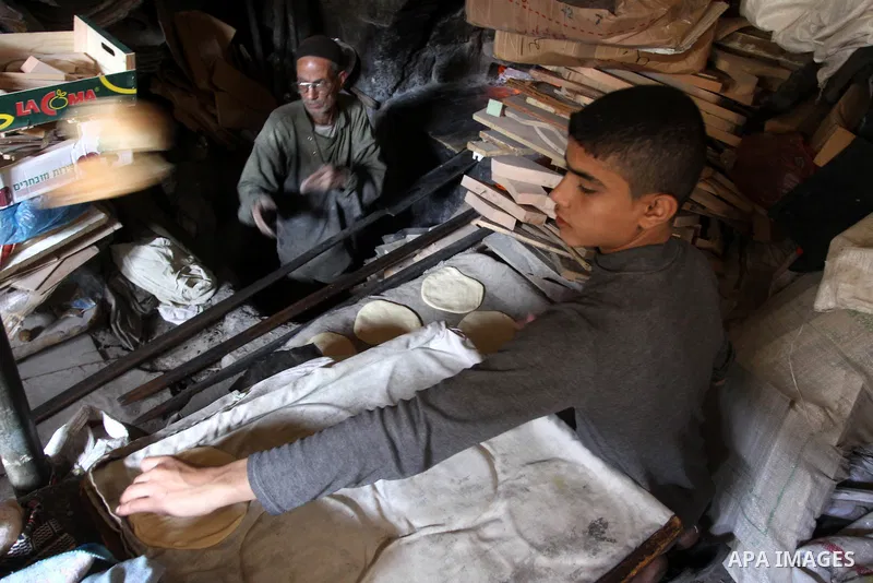 A Palestinian baker prepares loaves of bread at his traditional bakery in Gaza City on Jan. 20, 2011. The flour is running out and there will be a crisis within two days because of Israel's refused to allow some flour to...