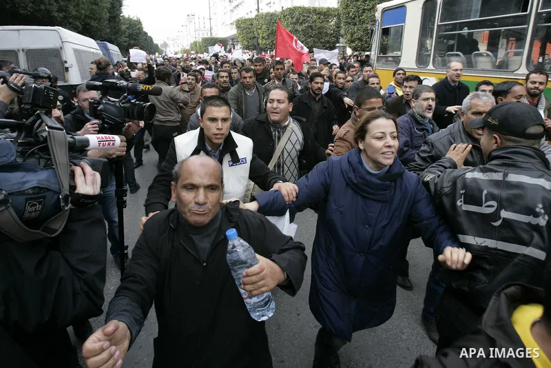 Tunisians take part in a protest in front of the headquarters of the Constitutional Democratic Rally (RCD) party of ousted president Zine al-Abidine Ben Ali during a demonstration in downtown Tunis, January 20, 2011. Tun...