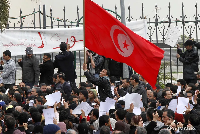 Tunisians take part in a protest in front of the headquarters of the Constitutional Democratic Rally (RCD) party of ousted president Zine al-Abidine Ben Ali during a demonstration in downtown Tunis, January 20, 2011. Tun...