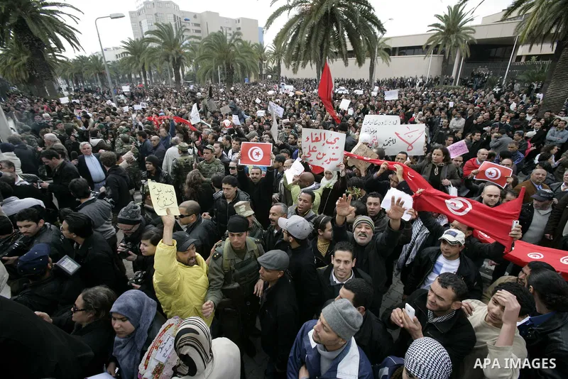 Tunisians take part in a protest in front of the headquarters of the Constitutional Democratic Rally (RCD) party of ousted president Zine al-Abidine Ben Ali during a demonstration in downtown Tunis, January 20, 2011. Tun...
