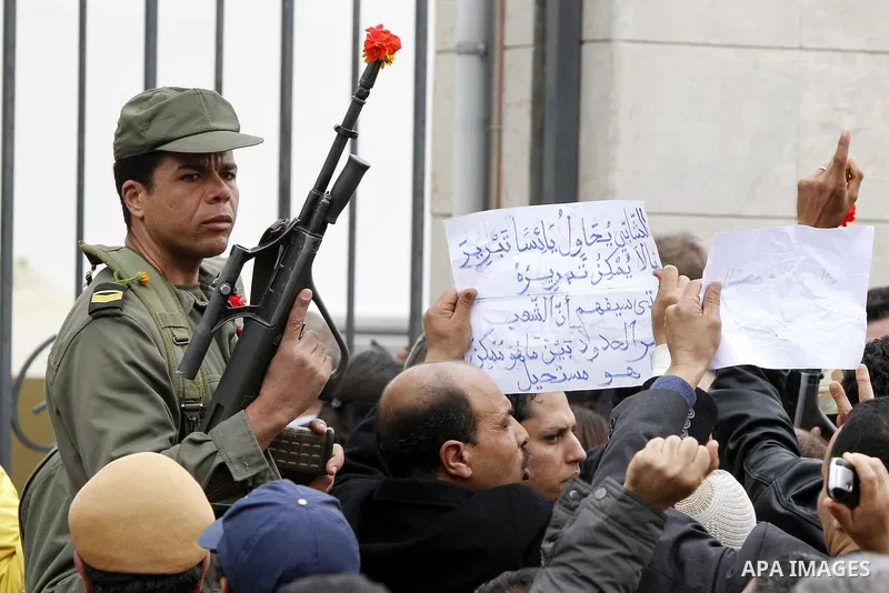 Tunisians take part in a protest in front of the headquarters of the Constitutional Democratic Rally (RCD) party of ousted president Zine al-Abidine Ben Ali during a demonstration in downtown Tunis, January 20, 2011. Tun...