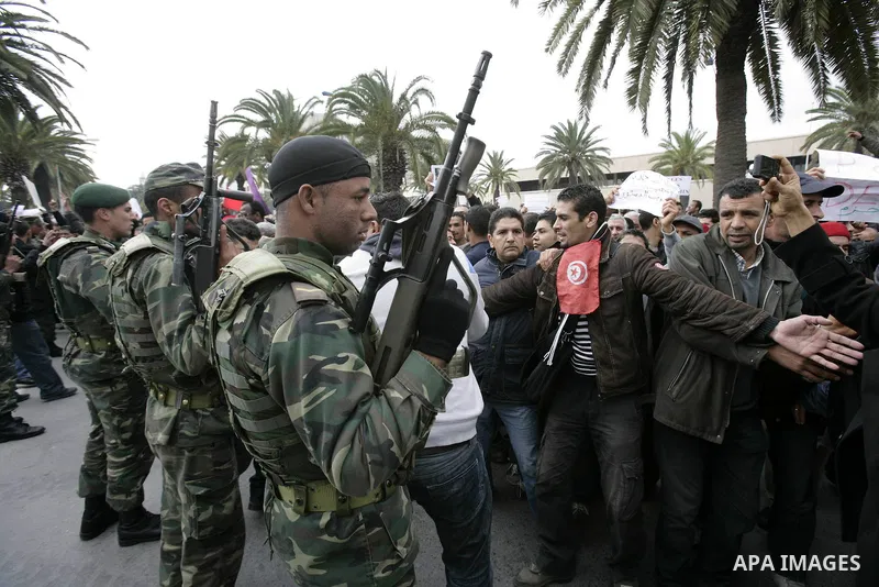 Tunisians take part in a protest in front of the headquarters of the Constitutional Democratic Rally (RCD) party of ousted president Zine al-Abidine Ben Ali during a demonstration in downtown Tunis, January 20, 2011. Tun...