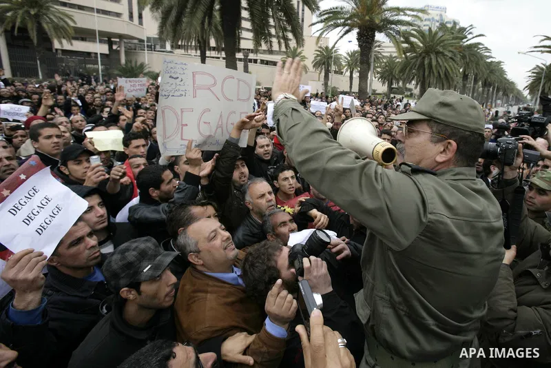 Tunisians take part in a protest in front of the headquarters of the Constitutional Democratic Rally (RCD) party of ousted president Zine al-Abidine Ben Ali during a demonstration in downtown Tunis, January 20, 2011. Tun...