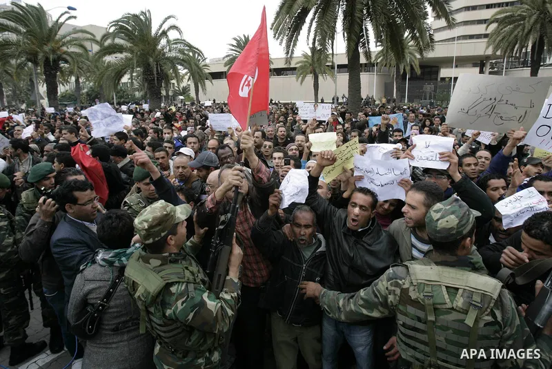 Tunisians take part in a protest in front of the headquarters of the Constitutional Democratic Rally (RCD) party of ousted president Zine al-Abidine Ben Ali during a demonstration in downtown Tunis, January 20, 2011. Tun...