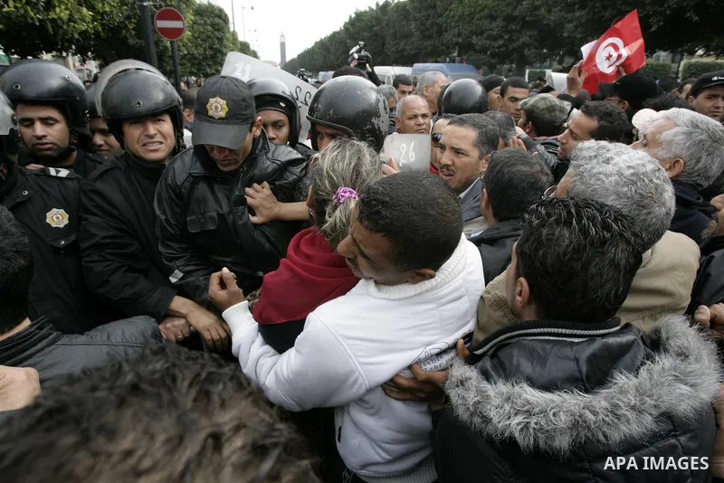 Tunisians take part in a protest in front of the headquarters of the Constitutional Democratic Rally (RCD) party of ousted president Zine al-Abidine Ben Ali during a demonstration in downtown Tunis, January 20, 2011. Tun...
