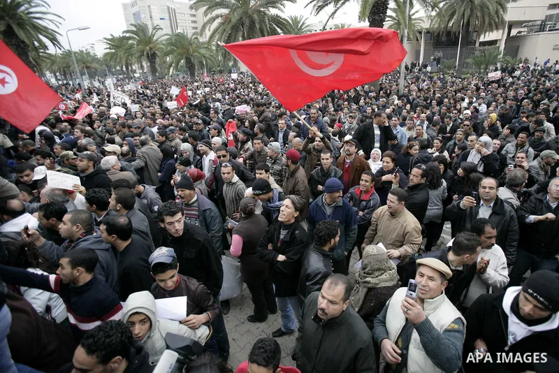 Tunisians take part in a protest in front of the headquarters of the Constitutional Democratic Rally (RCD) party of ousted president Zine al-Abidine Ben Ali during a demonstration in downtown Tunis, January 20, 2011. Tun...