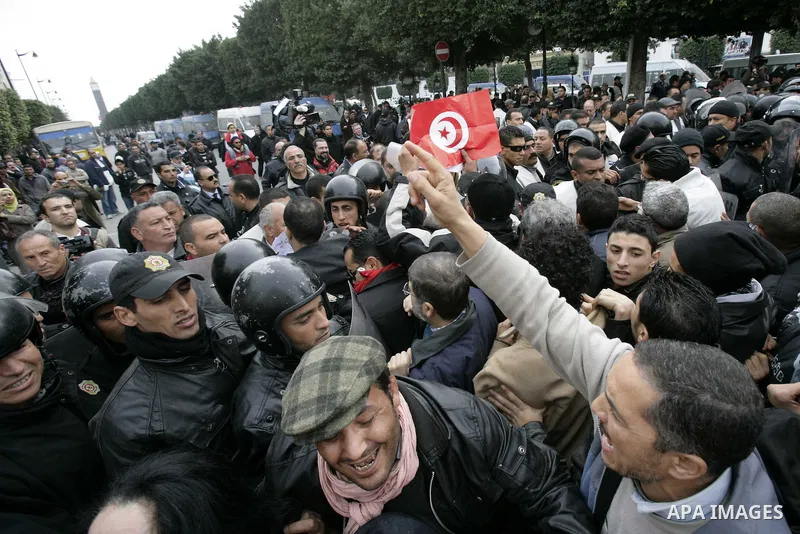Tunisians take part in a protest in front of the headquarters of the Constitutional Democratic Rally (RCD) party of ousted president Zine al-Abidine Ben Ali during a demonstration in downtown Tunis, January 20, 2011. Tun...