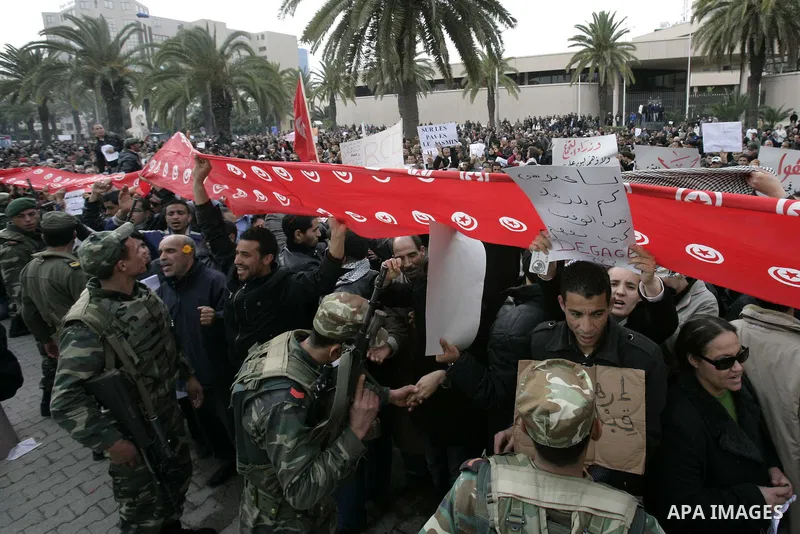 Tunisians take part in a protest in front of the headquarters of the Constitutional Democratic Rally (RCD) party of ousted president Zine al-Abidine Ben Ali during a demonstration in downtown Tunis, January 20, 2011. Tun...