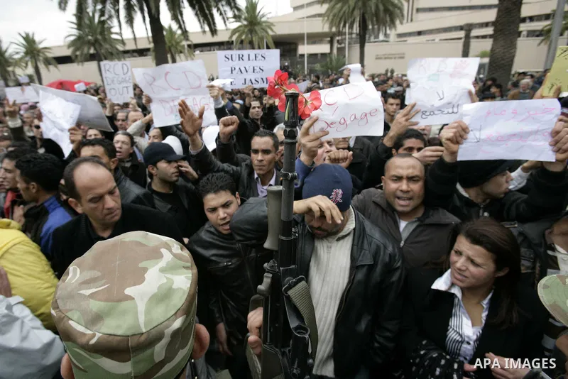 Tunisians take part in a protest in front of the headquarters of the Constitutional Democratic Rally (RCD) party of ousted president Zine al-Abidine Ben Ali during a demonstration in downtown Tunis, January 20, 2011. Tun...