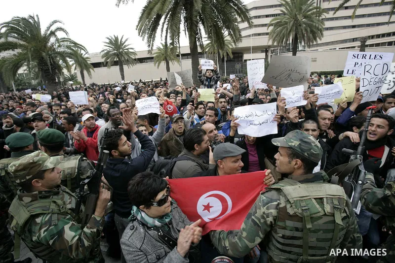 Tunisians take part in a protest in front of the headquarters of the Constitutional Democratic Rally (RCD) party of ousted president Zine al-Abidine Ben Ali during a demonstration in downtown Tunis, January 20, 2011. Tun...