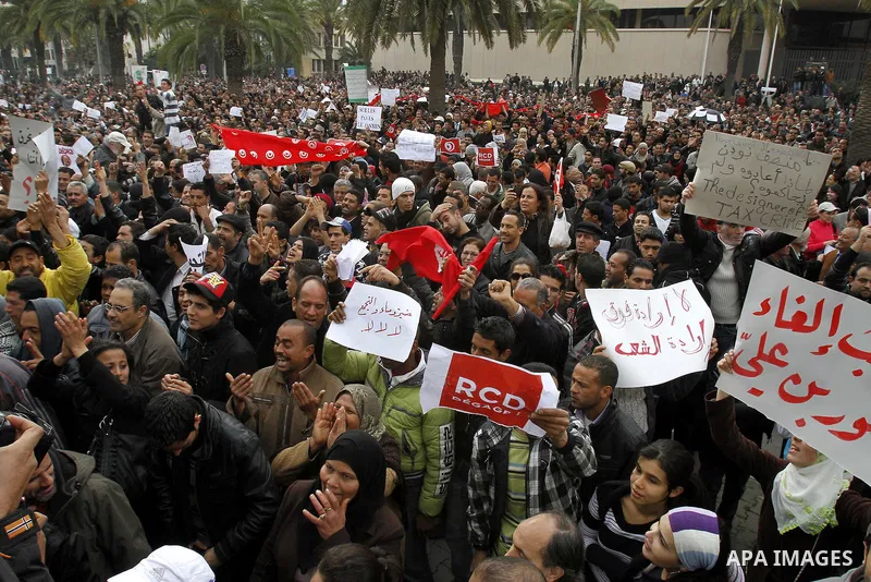 Tunisians take part in a protest in front of the headquarters of the Constitutional Democratic Rally (RCD) party of ousted president Zine al-Abidine Ben Ali during a demonstration in downtown Tunis, January 20, 2011. Tun...
