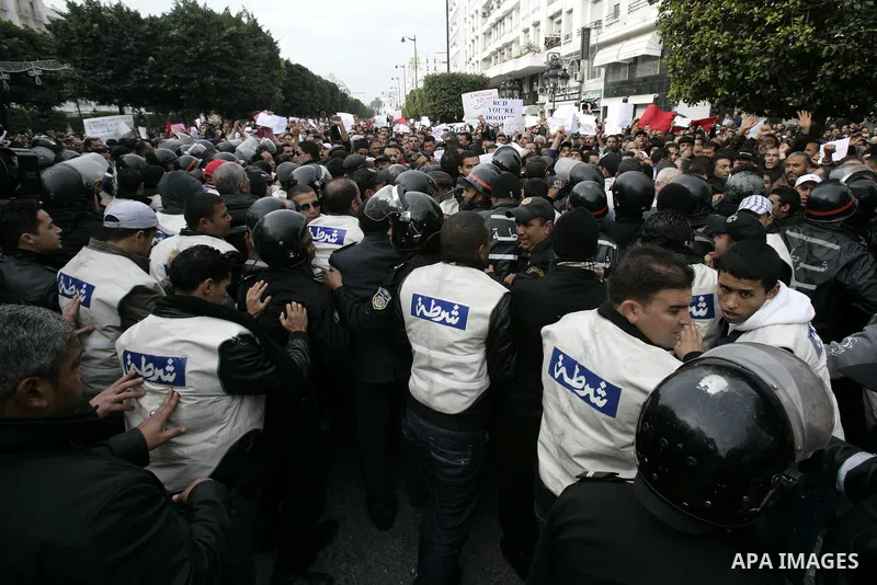 Tunisians take part in a protest in front of the headquarters of the Constitutional Democratic Rally (RCD) party of ousted president Zine al-Abidine Ben Ali during a demonstration in downtown Tunis, January 20, 2011. Tun...