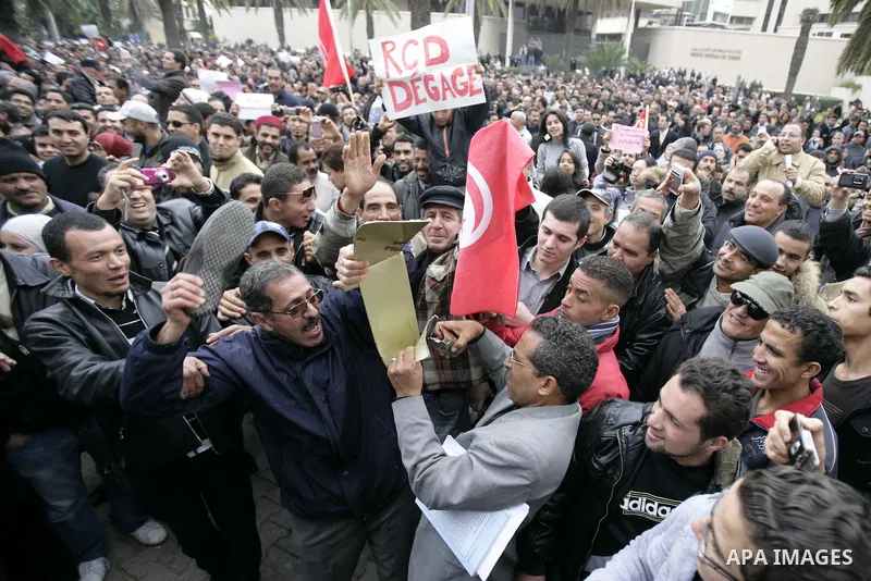 Tunisians take part in a protest in front of the headquarters of the Constitutional Democratic Rally (RCD) party of ousted president Zine al-Abidine Ben Ali during a demonstration in downtown Tunis, January 20, 2011. Tun...