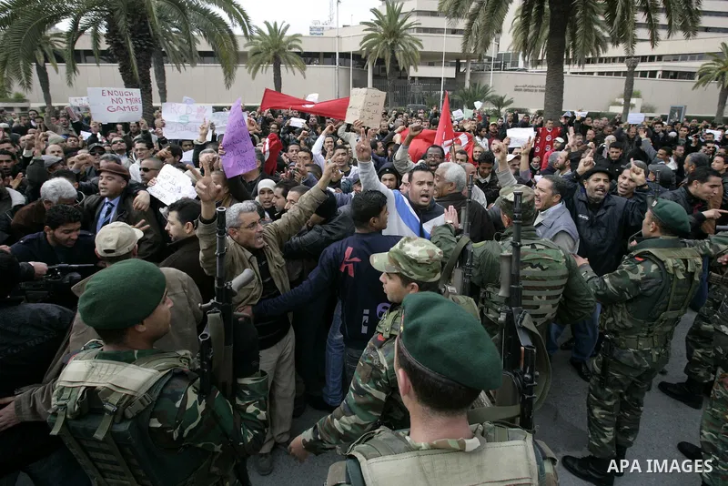 Tunisians take part in a protest in front of the headquarters of the Constitutional Democratic Rally (RCD) party of ousted president Zine al-Abidine Ben Ali during a demonstration in downtown Tunis, January 20, 2011. Tun...