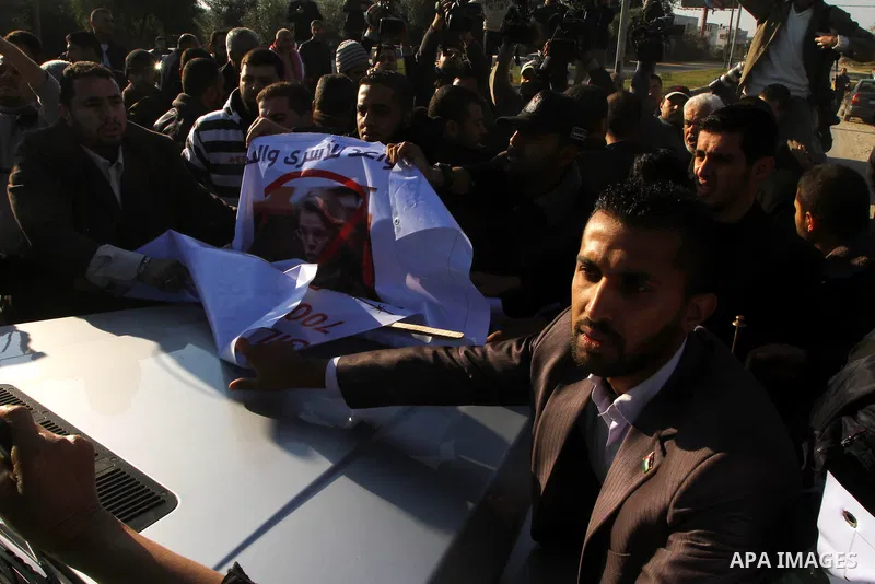 Palestinian relatives of a prisoners jailed in Israel hold posters as they block the vehicle carrying French Foreign Minister Michele Alliot-Marie as it makes its way into Gaza Strip, on the Palestinian side of the Erez...