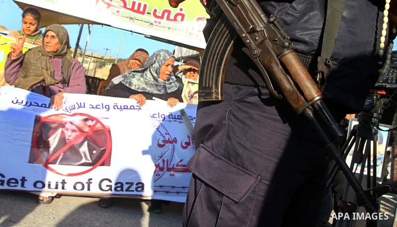 Palestinian relatives of a prisoners jailed in Israel hold posters as they block the vehicle carrying French Foreign Minister Michele Alliot-Marie as it makes its way into Gaza Strip, on the Palestinian side of the Erez...