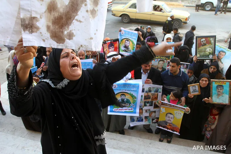 Relatives of Palestinians being held in Israeli jails hold pictures of them as French Foreign Minister Michele Alliot-Marie visits U.N. headquarters in Gaza City, on Jan. 21, 2011. A crowd of furious Palestinian proteste...