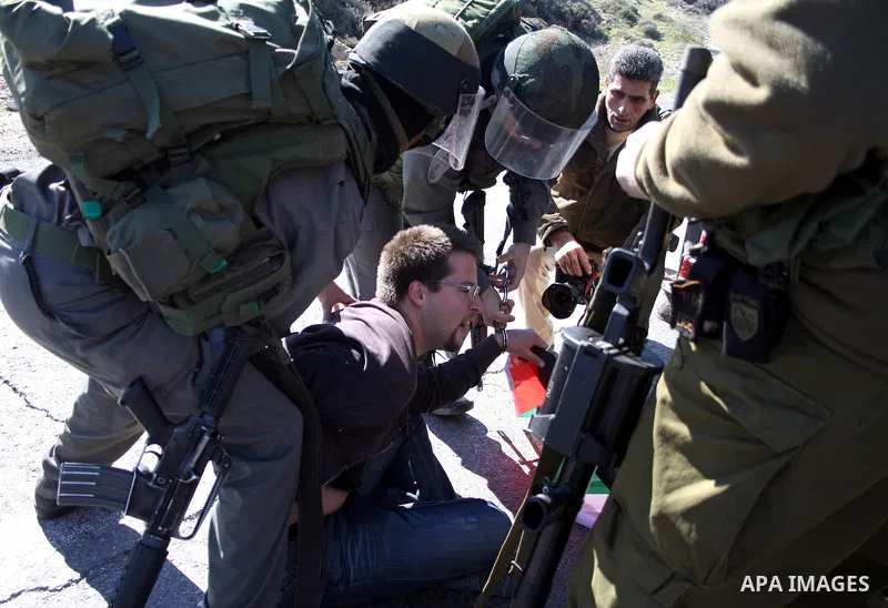Israeli soldiers arrest a demonstrator during a protest against Israel's controversial separation barrier in the West Bank village of Maasarah, near Bethlehem, on January 21, 2011. Israel says the network of steel and co...