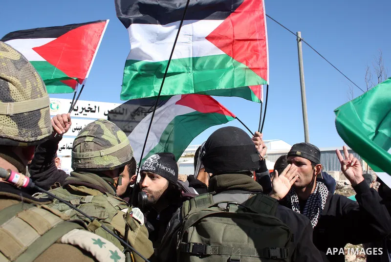 Israeli soldiers stand guard as Palestinian, Israeli and foreign protesters take part in a demonstration against Israel's controversial separation barrier in the West Bank village of Maasarah, near Bethlehem, on January...