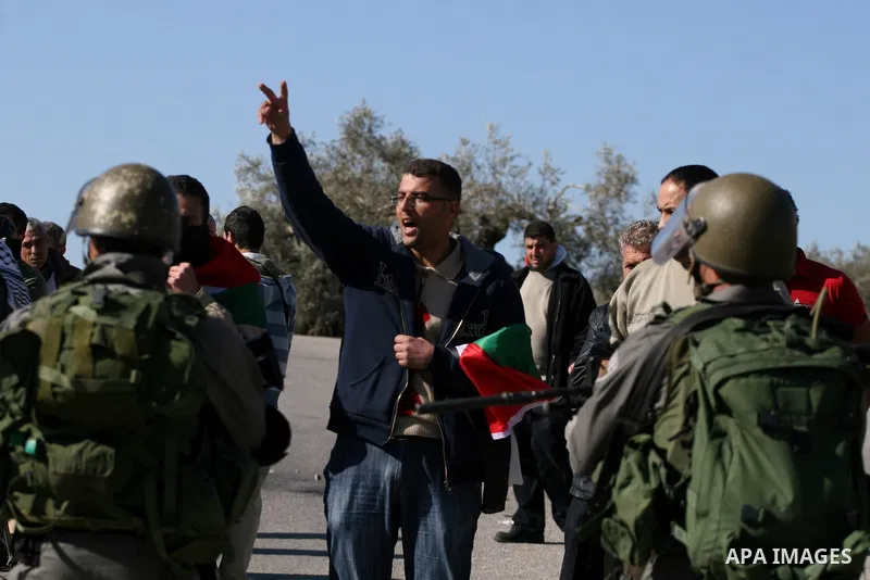 Palestinian protesters take part in a demonstration against the expansion of the nearby Jewish settlement of Halamish in the West Bank village of Nabi Saleh, near Ramallah, Friday, Jan. 21, 2011. Photo by Issam Rimawi