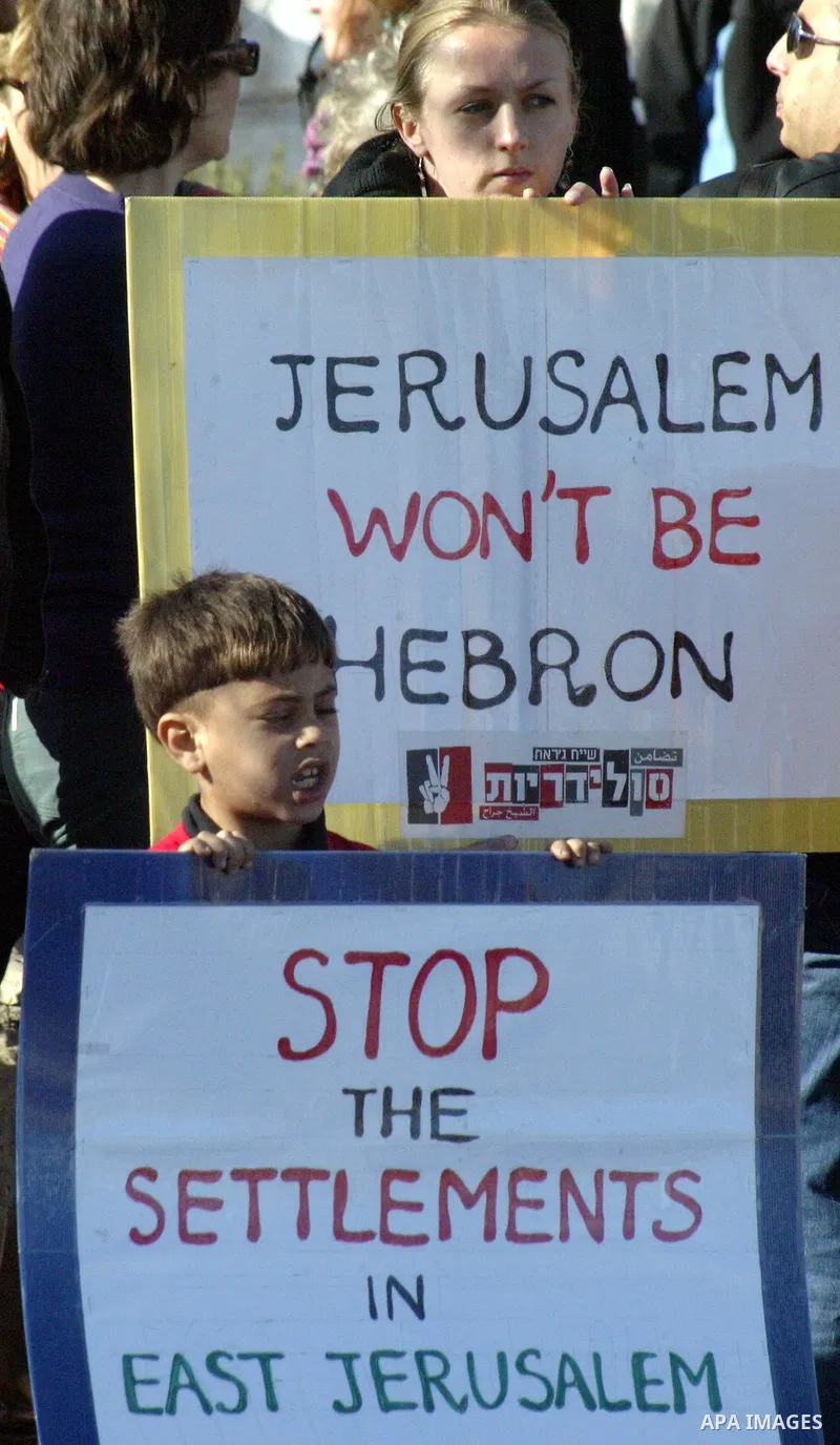 Palestinians, Israelis and foreign activists hold signs during a protest to show solidarity with Palestinian families against a Jewish settlement in the Sheikh Jarrah neighbourhood in East Jerusalem on Jan. 21, 2011. Pho...