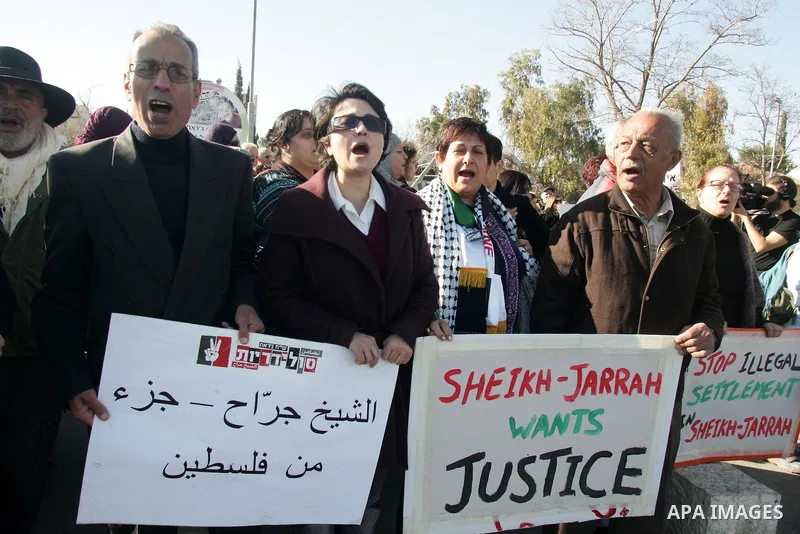 Palestinians, Israelis and foreign activists hold signs during a protest to show solidarity with Palestinian families against a Jewish settlement in the Sheikh Jarrah neighbourhood in East Jerusalem on Jan. 21, 2011. Pho...