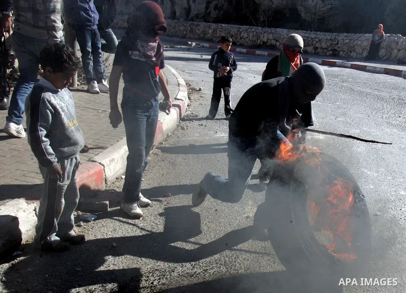 Masked Palestinian youths prepare to throw stones at Israeli forces during clashes in the Arab east Jerusalem neighbourhood of Silwan on January 21, 2011. Photo by Mahfouz Abu Turk