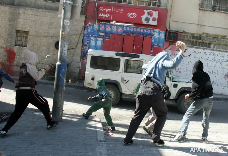 Masked Palestinian youths prepare to throw stones at Israeli forces during clashes in the Arab east Jerusalem neighbourhood of Silwan on January 21, 2011. Photo by Mahfouz Abu Turk