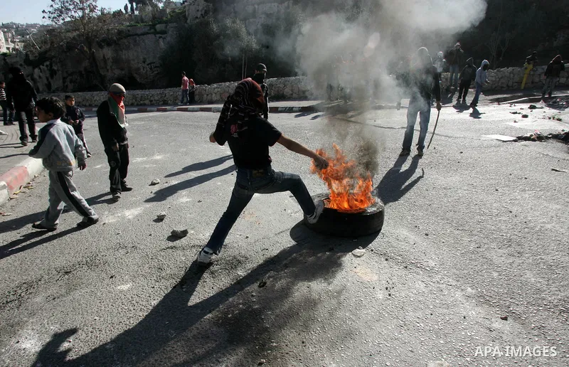 Masked Palestinian youths prepare to throw stones at Israeli forces during clashes in the Arab east Jerusalem neighbourhood of Silwan on January 21, 2011. Photo by Mahfouz Abu Turk