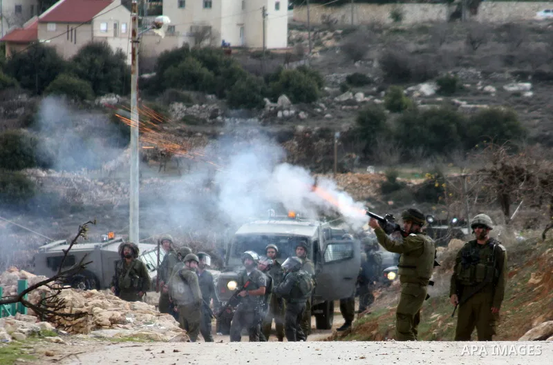 An Israeli soldier fires tear gas canister towards demonstrators during a protest by Palestinian, Israeli and foreign activists against the demolishing of farm land to be used in the construction of Jewish settlements ne...