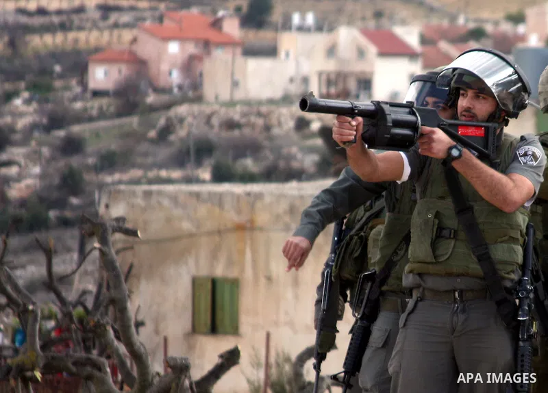 An Israeli soldier fires tear gas canister towards demonstrators during a protest by Palestinian, Israeli and foreign activists against the demolishing of farm land to be used in the construction of Jewish settlements ne...