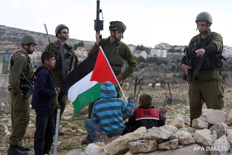 Israeli soldiers stand guard during a demonstration by Palestinian, Israeli and foreign activists against the demolishing of farm land to be used in the construction of Jewish settlements near the existing Israeli settle...
